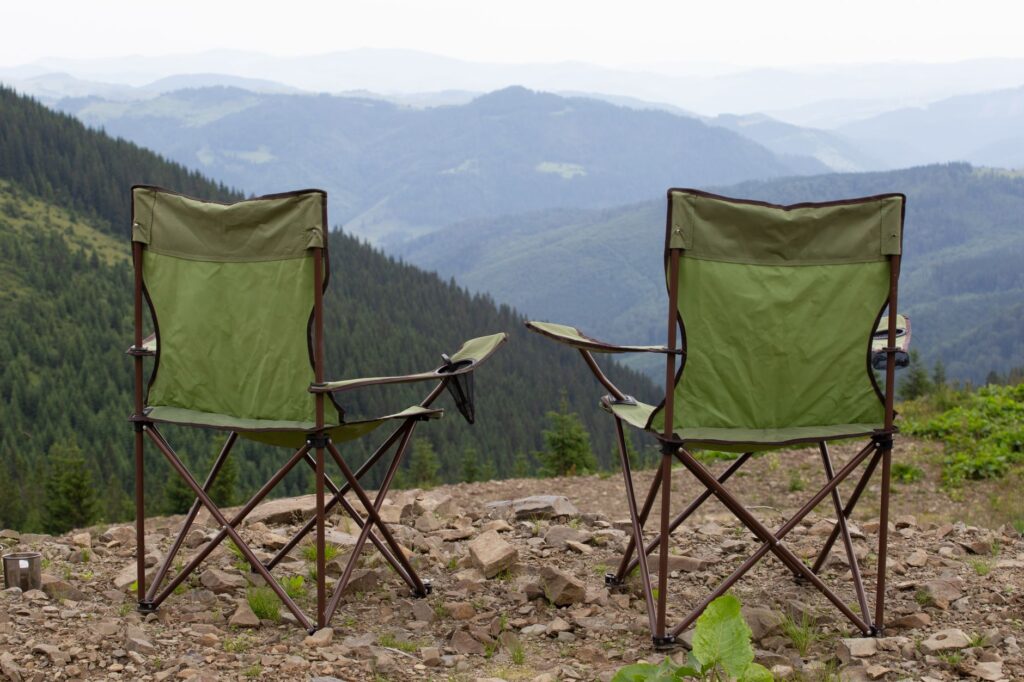 Two folding chairs facing a serene mountain view, perfect for outdoor relaxation.