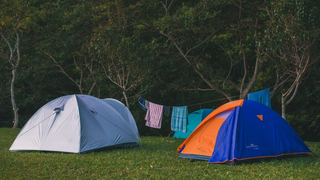 Scenic view of camping tents and clothes drying on a line in a forest.
